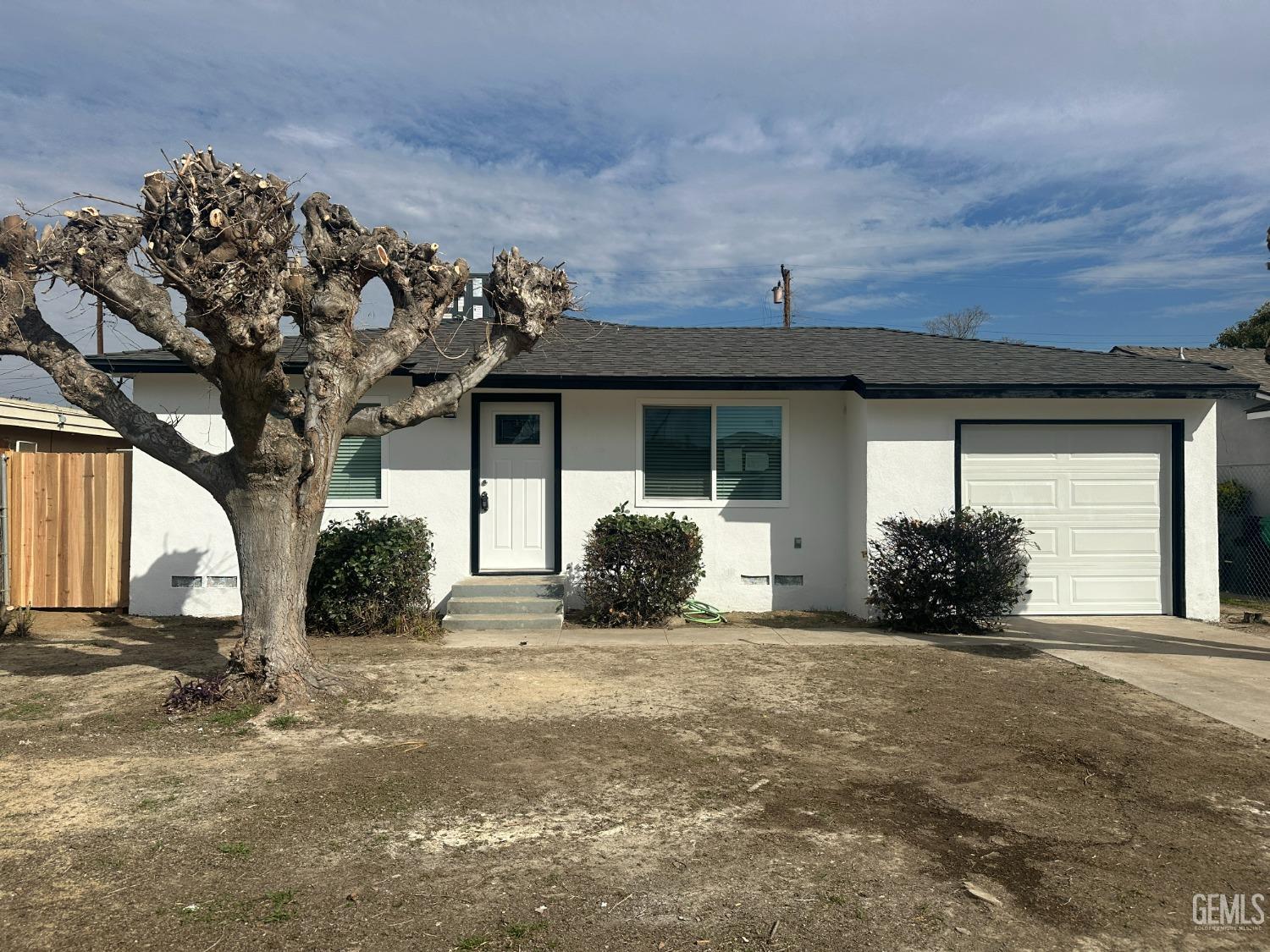 a view of a house with a yard and large tree
