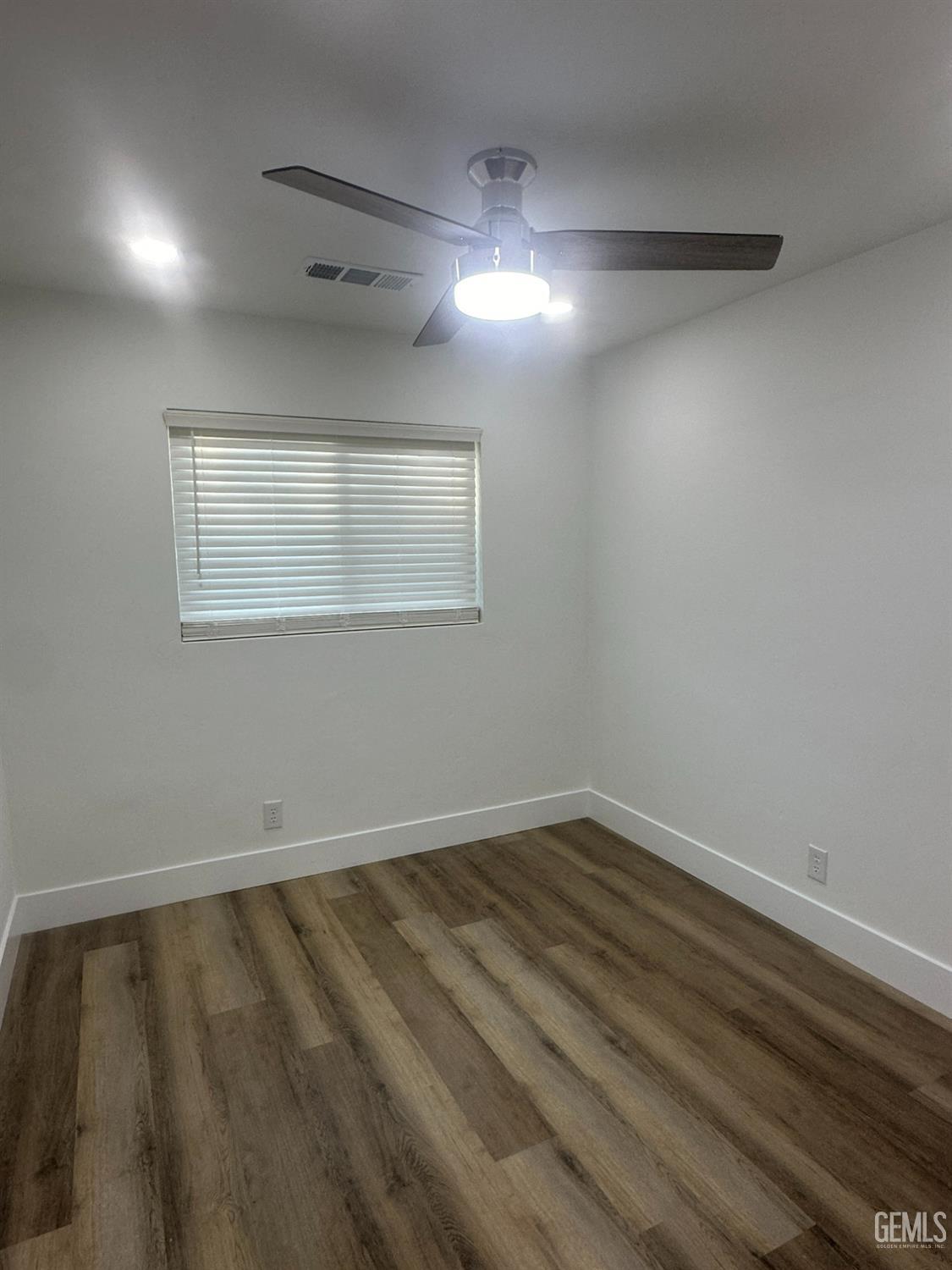Undisclosed Address Shafter, CA 93263 - Photo 11 of 21 en empty room with wooden floor and windows