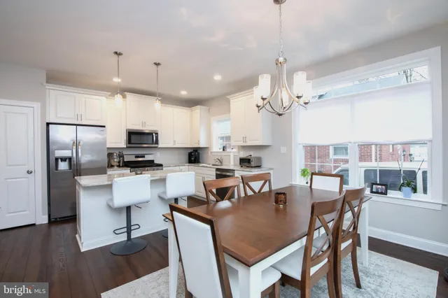 a view of kitchen with refrigerator a dining table and chairs