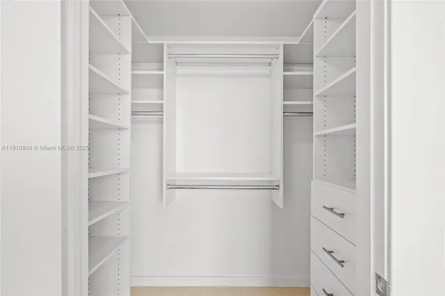a view of walk in closet with empty racks