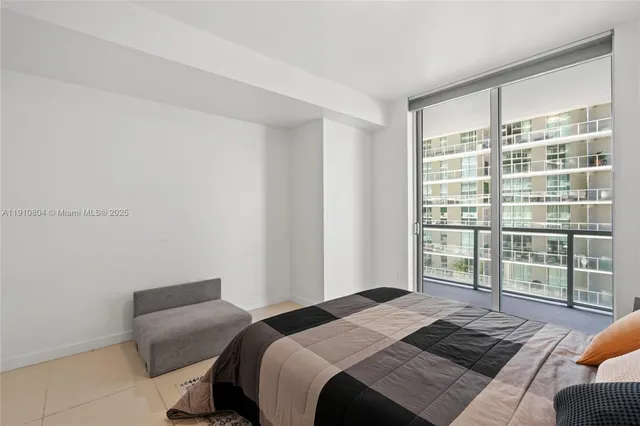 a bedroom with a bed and a large window