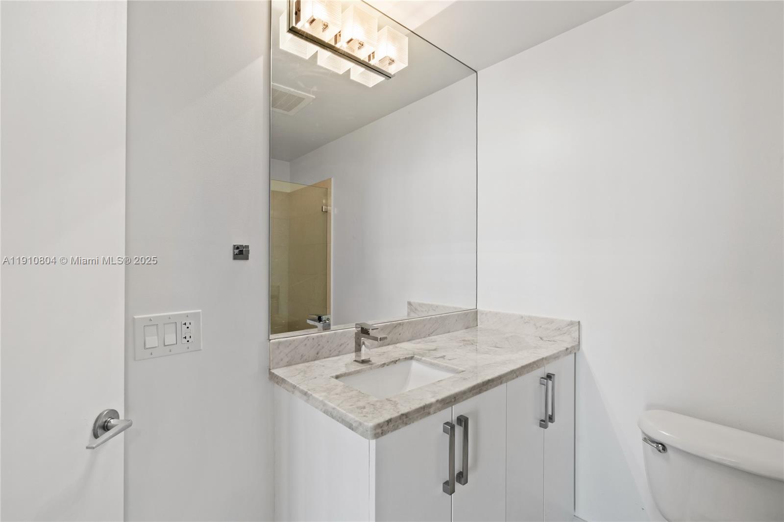 1111 Southwest 1st Avenue, Unit 2414N Miami, FL 33130 - Photo 27 of 49 a bathroom with a granite countertop sink and a mirror