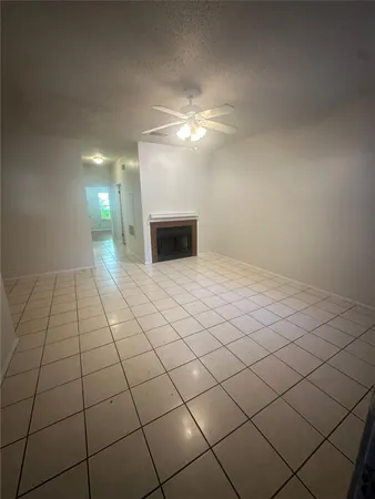a view of a livingroom with a chandelier fan and window