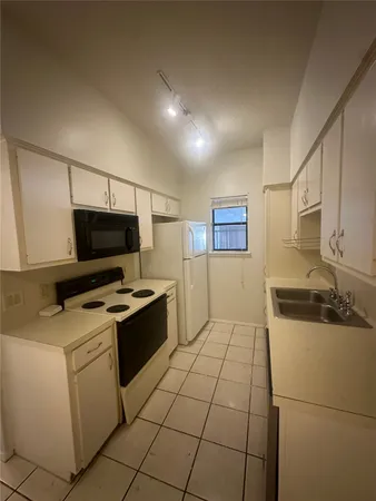 a kitchen with a stove a sink and a refrigerator