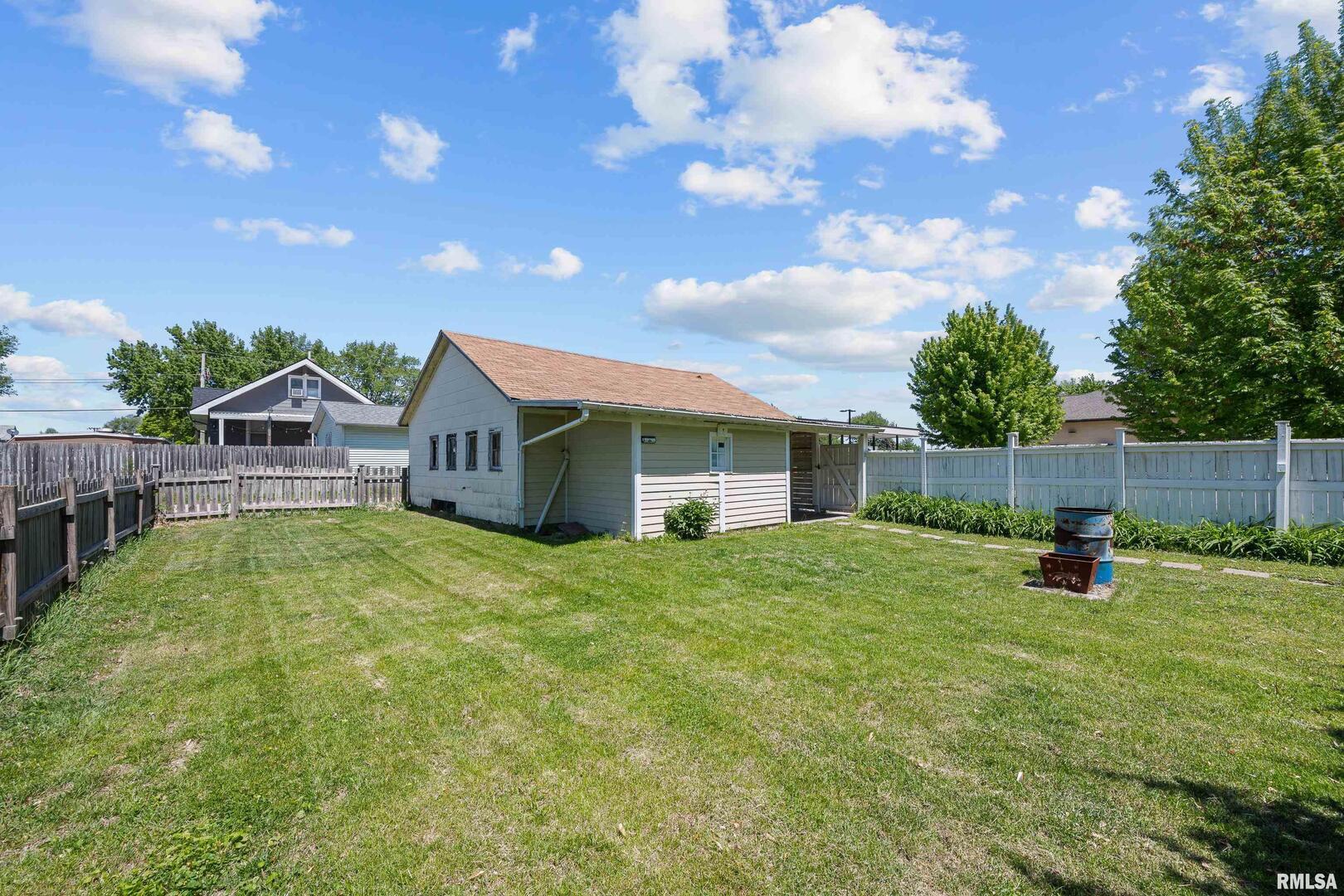 126 South Genessee Street Blue Grass, IA 52726 - Photo 14 of 22 a backyard of a house with table and chairs