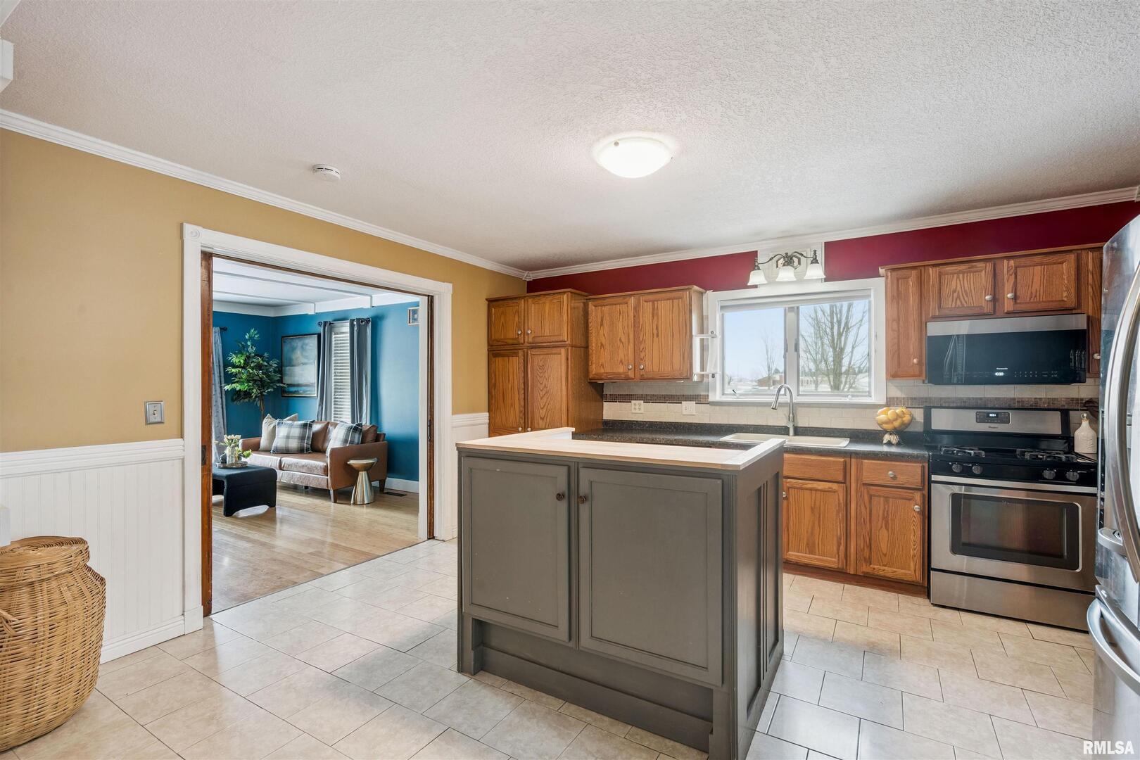 126 South Genessee Street Blue Grass, IA 52726 - Photo 8 of 22 a kitchen with stainless steel appliances granite countertop a stove a sink and a microwave