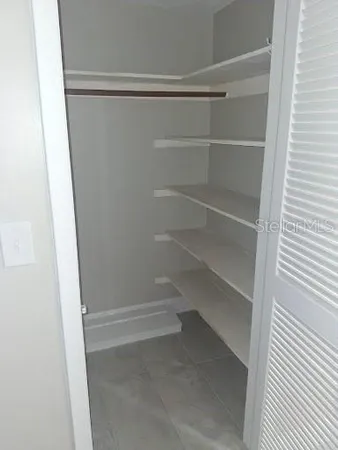 a view of walk in closet with empty racks