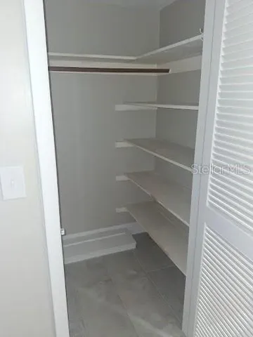 a view of walk in closet with empty racks