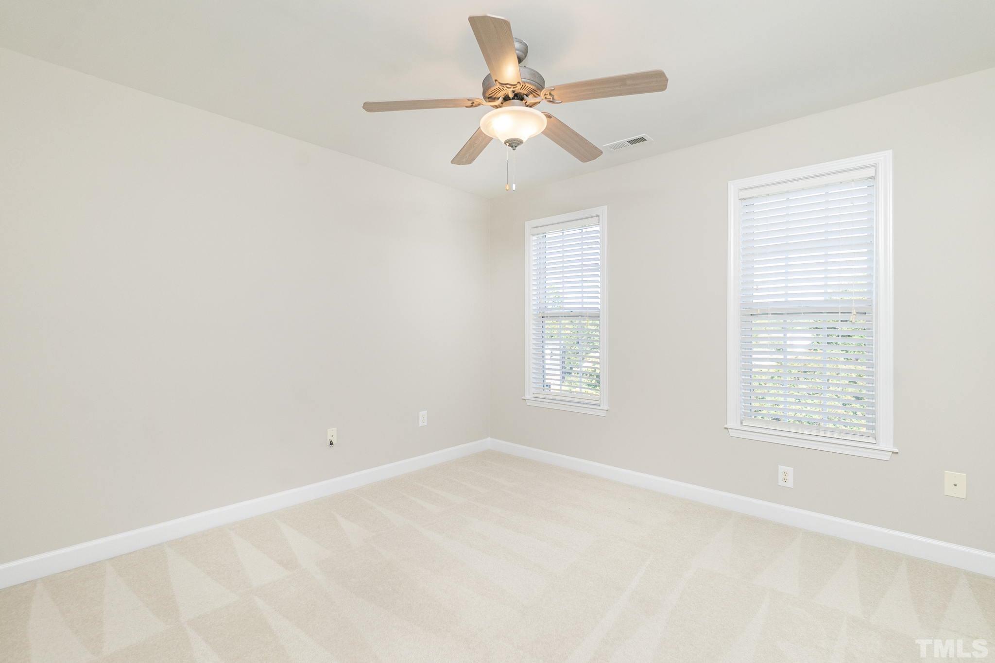 4812 Elmhurst Ridge Court Raleigh, NC 27616 - Photo 12 of 23 an empty room with a window and a fan