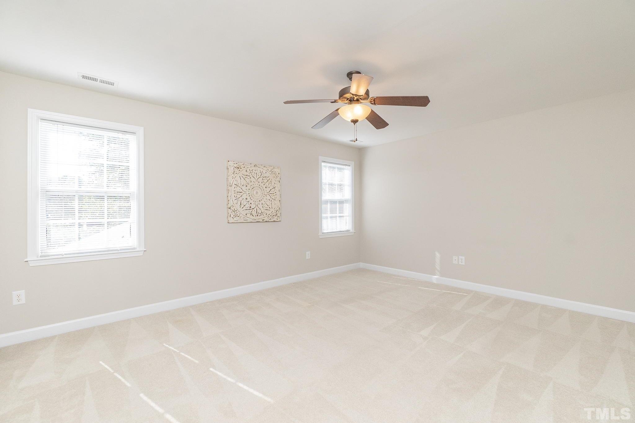4812 Elmhurst Ridge Court Raleigh, NC 27616 - Photo 15 of 23 an empty room with windows and fan