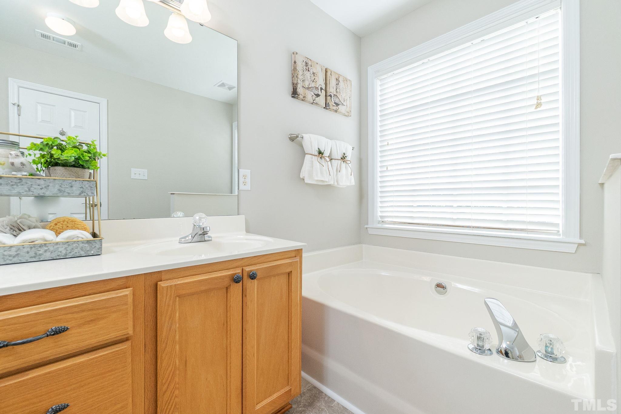 4812 Elmhurst Ridge Court Raleigh, NC 27616 - Photo 17 of 23 a bathroom with a tub sink and mirror