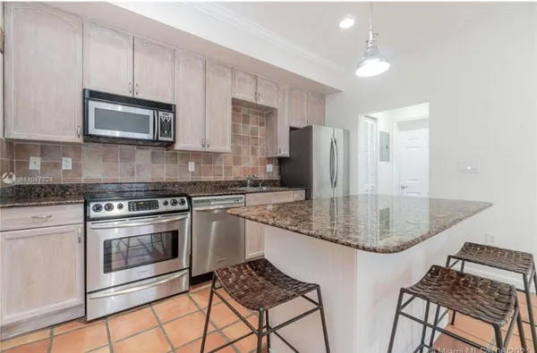 a kitchen with stainless steel appliances granite countertop a stove a sink and a microwave
