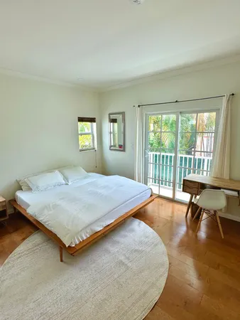 a bedroom with a bed and a large window