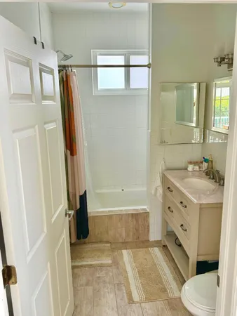 a bathroom with a tub sink toilet and a mirror