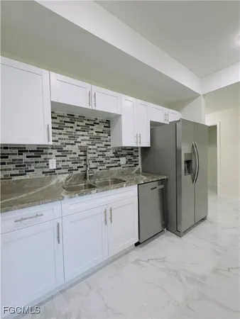 a kitchen with granite countertop white cabinets and stainless steel appliances
