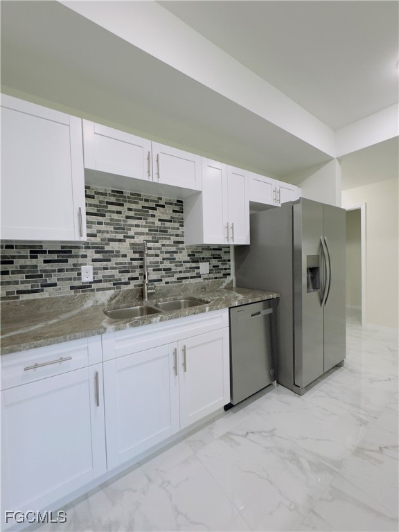 884 Alabama Road South Lehigh Acres, FL 33974 - Photo 15 of 37 a kitchen with granite countertop white cabinets and stainless steel appliances