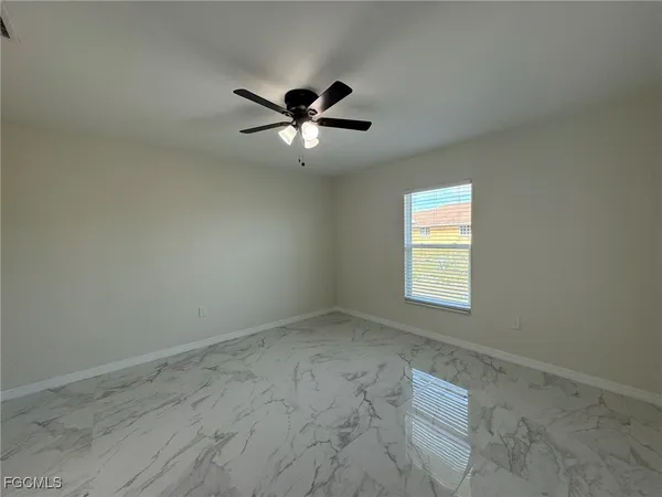 an empty room with a window and a fan