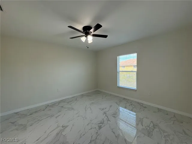 an empty room with a window and a fan