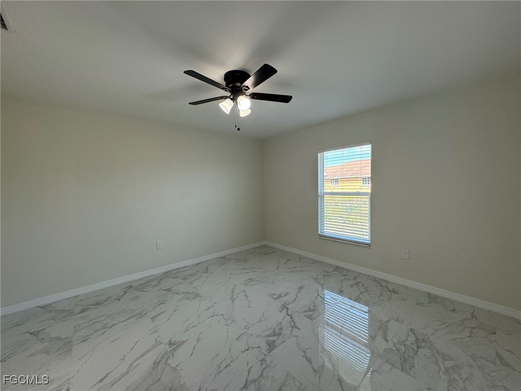 884 Alabama Road South Lehigh Acres, FL 33974 - Photo 16 of 37 an empty room with a window and a fan