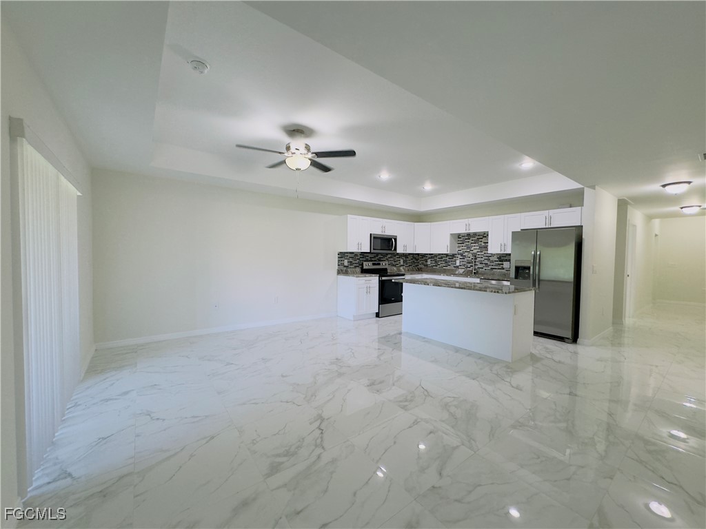 884 Alabama Road South Lehigh Acres, FL 33974 - Photo 2 of 37 a view of kitchen with stainless steel appliances refrigerator stove microwave and cabinets
