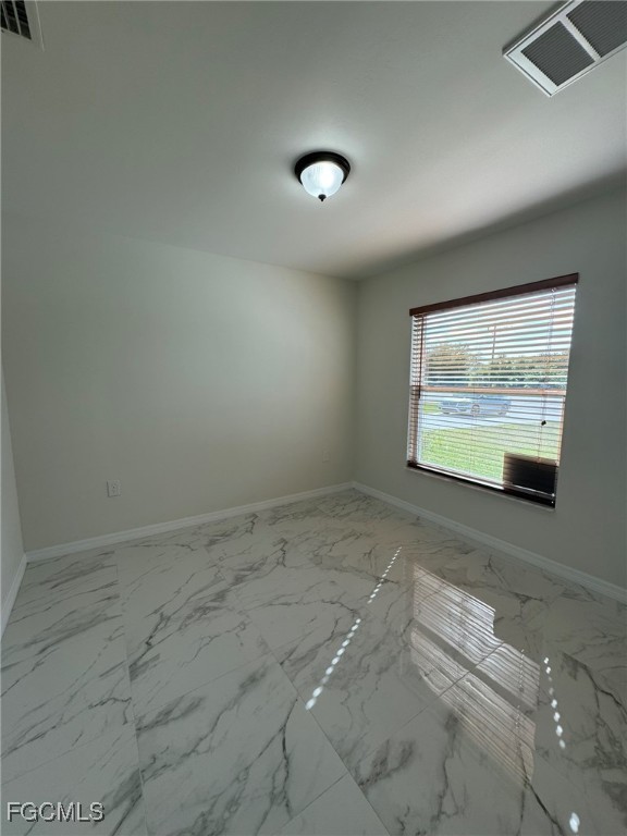 884 Alabama Road South Lehigh Acres, FL 33974 - Photo 27 of 37 a view of an empty room with windows
