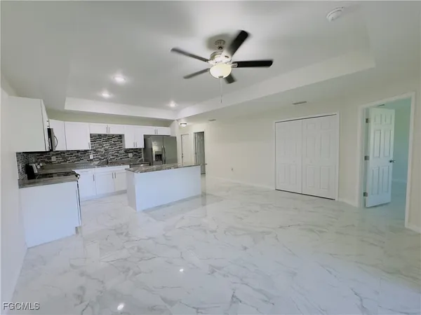 a kitchen with a refrigerator and white cabinets