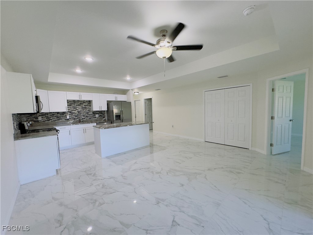 884 Alabama Road South Lehigh Acres, FL 33974 - Photo 3 of 37 a kitchen with a refrigerator and white cabinets