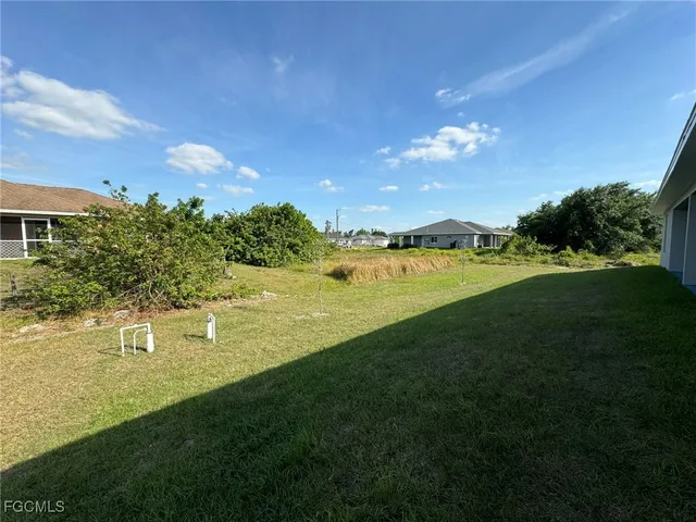 a backyard of a house with lots of green space and plants