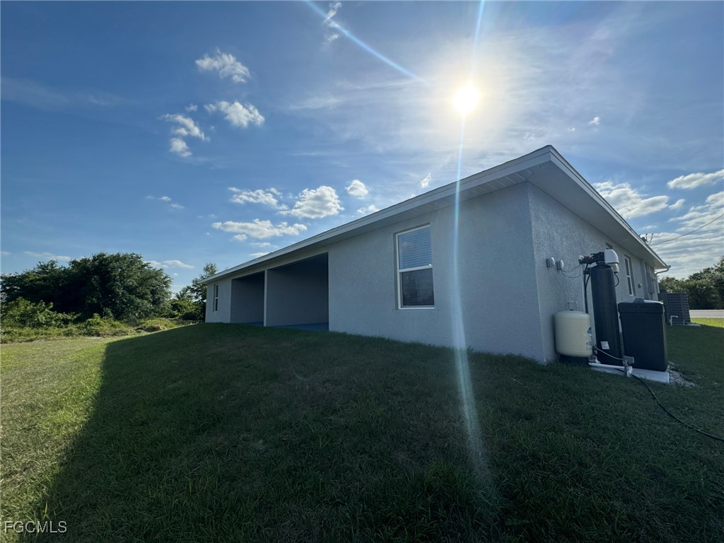 884 Alabama Road South Lehigh Acres, FL 33974 - Photo 35 of 37 a backyard of a house with lots of green space and plants
