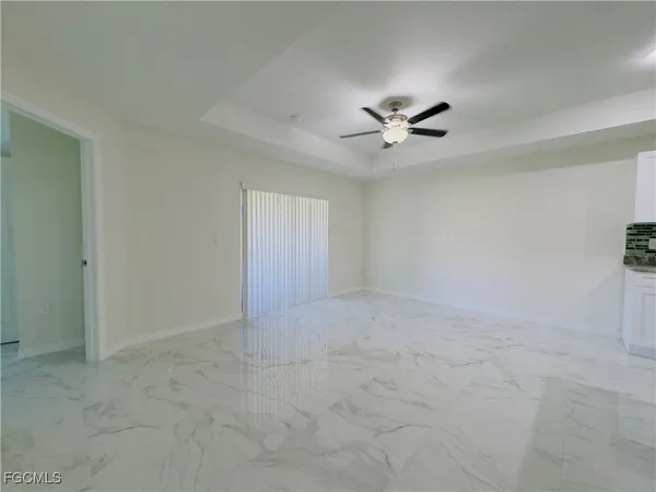 an empty room with a ceiling fan and a window