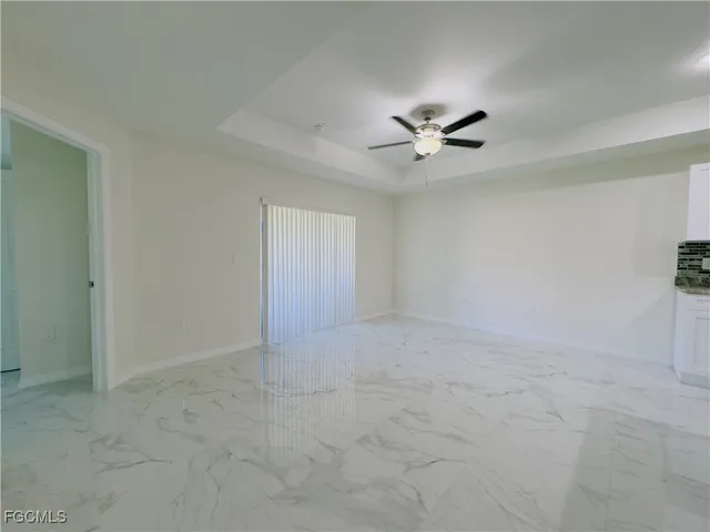 an empty room with a ceiling fan and a window