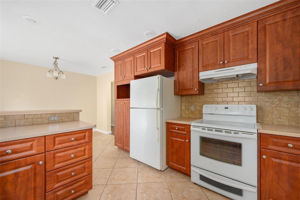 26443 Southwest 3rd Place Newberry, FL 32669 - Photo 11 of 26 a kitchen with granite countertop wooden cabinets and a stove top oven