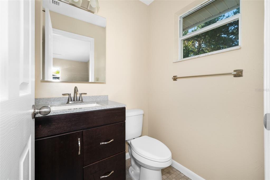 26443 Southwest 3rd Place Newberry, FL 32669 - Photo 18 of 26 a bathroom with a granite countertop toilet sink and mirror