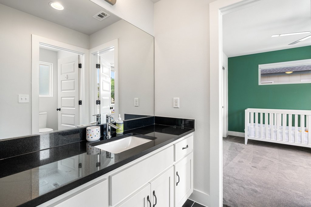 1182 Ridgeway Drive, Unit A Austin, TX 78702 - Photo 22 of 35 a kitchen with granite countertop a sink and a white cabinets