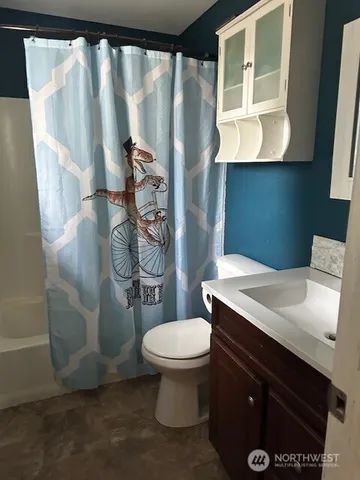 a bathroom with a sink a toilet and shower curtain