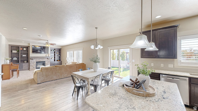 368 East 700 North Springville, UT 84663 - Photo 6 of 55 Dining space featuring a textured ceiling, a fireplace, light wood-type flooring, built in shelves, and a ceiling fan