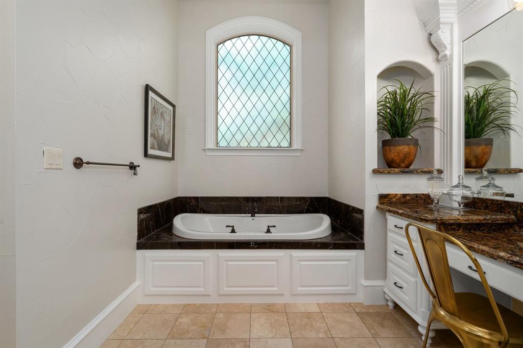 2101 Vail Road Southlake, TX 76092 - Photo 24 of 40 a bathroom with a tub a sink and mirror