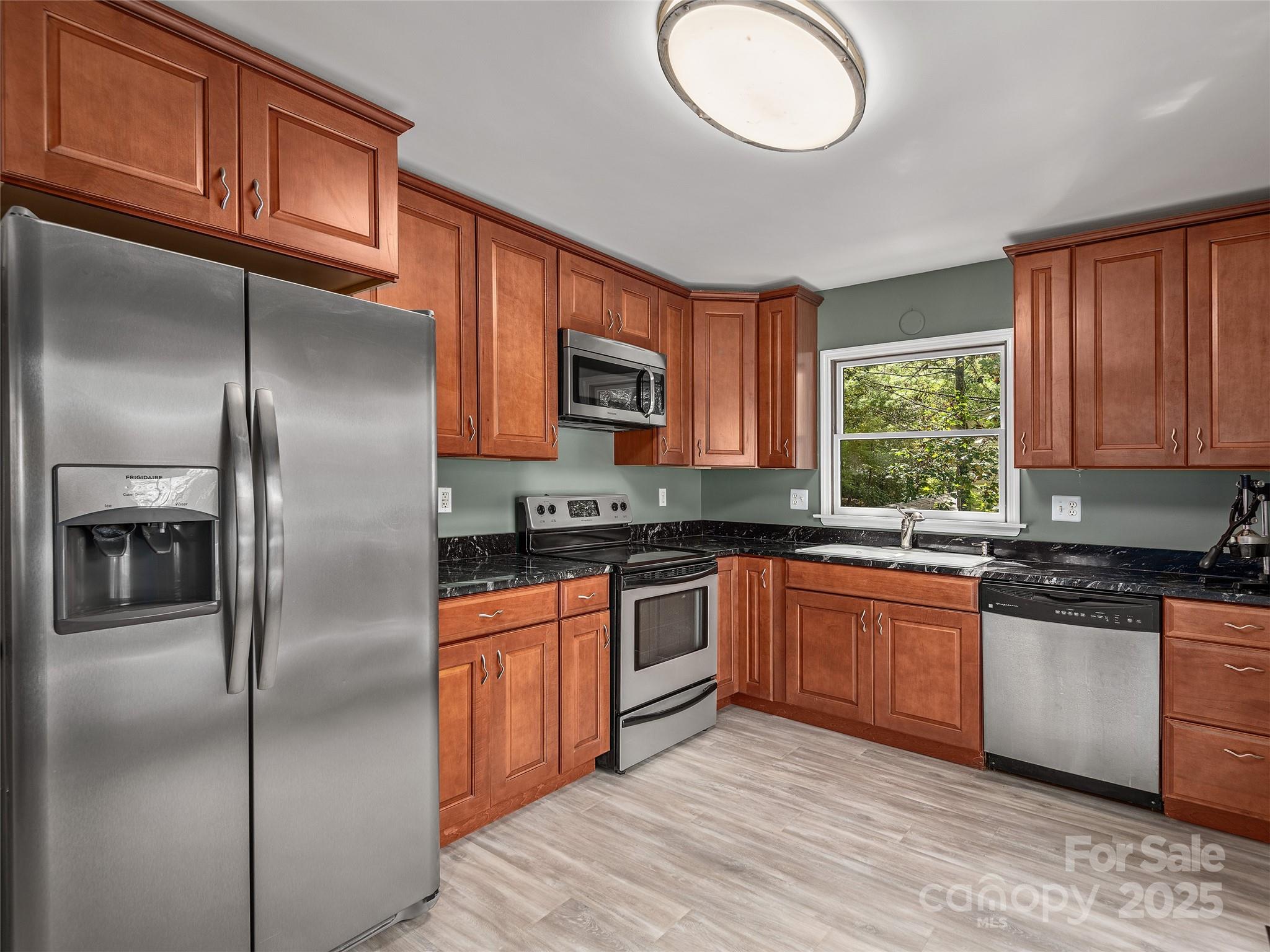 66 High Country Road Weaverville, NC 28787 - Photo 12 of 36 a kitchen with stainless steel appliances granite countertop a refrigerator a stove top oven a sink and dishwasher with wooden floor