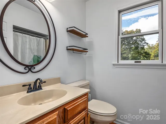 a bathroom with a sink a toilet and a mirror