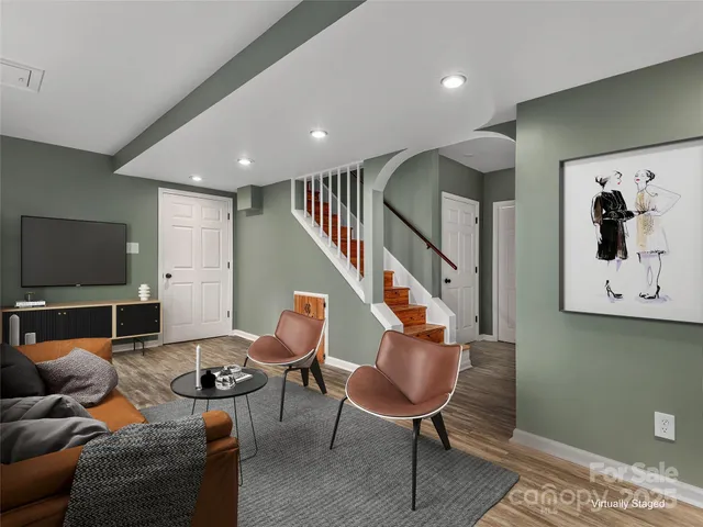 a living room with furniture kitchen view and a flat screen tv