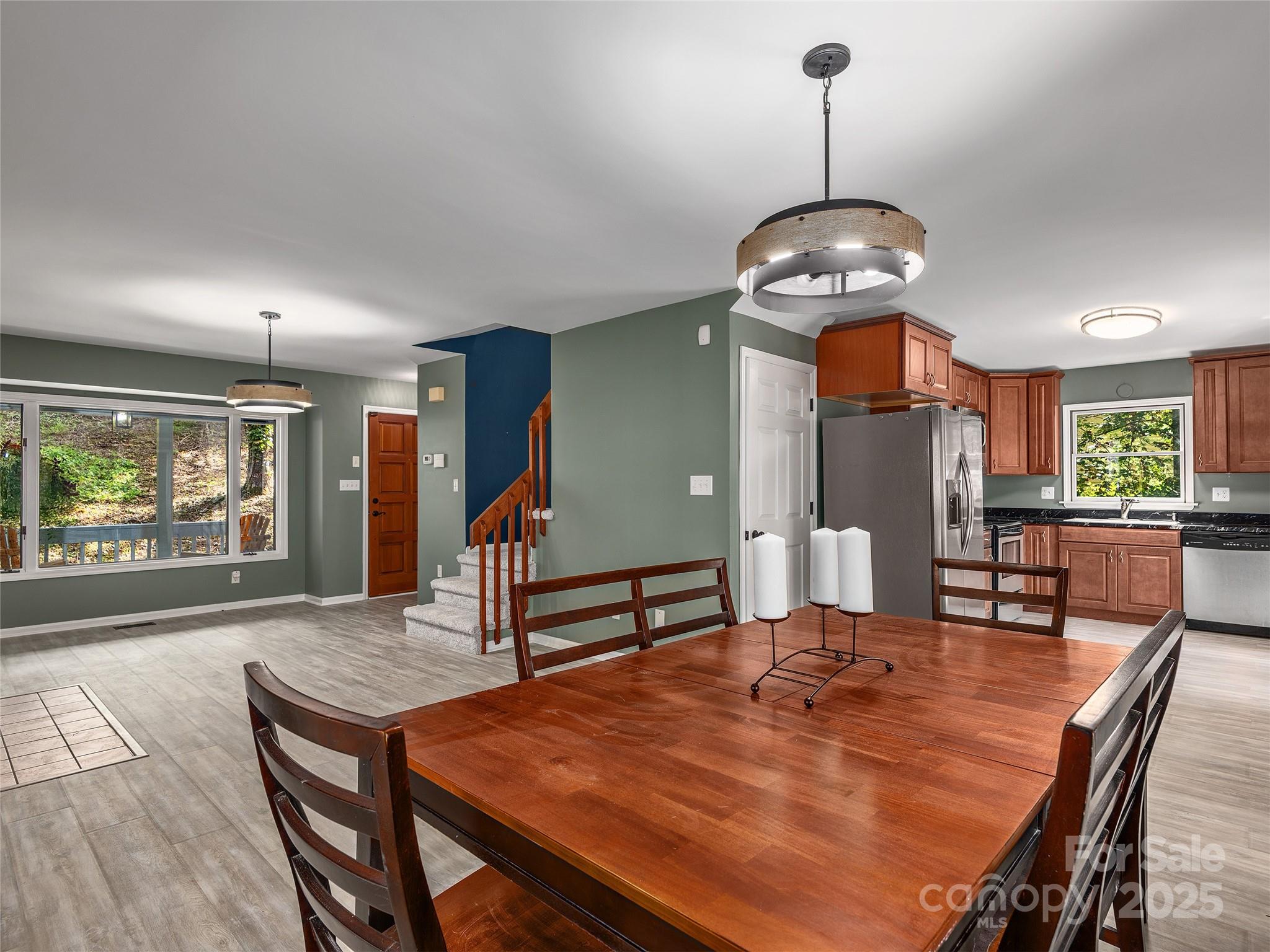 66 High Country Road Weaverville, NC 28787 - Photo 10 of 36 a dining room with wooden floor a chandelier a wooden table and chairs