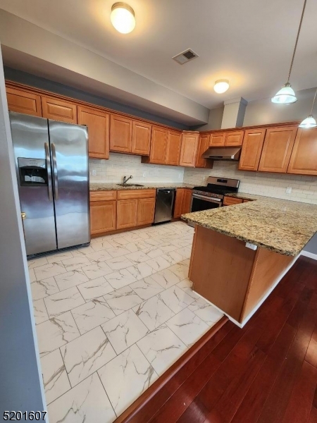 25 Cottage Street, Unit 7 Newark, NJ 07102 - Photo 3 of 5 a kitchen with stainless steel appliances kitchen island granite countertop a sink counter space and a window