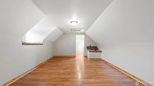 a view of a hallway with wooden floor and a window