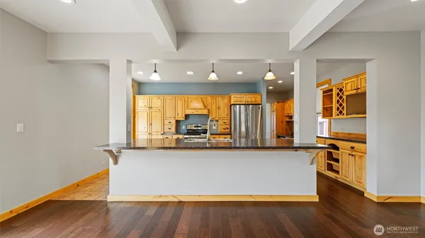 a kitchen with stainless steel appliances granite countertop a refrigerator a sink and white cabinets