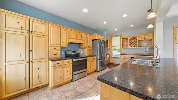 a large kitchen with stainless steel appliances granite countertop a stove and a sink