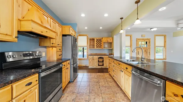 a kitchen with stainless steel appliances granite countertop a refrigerator and a sink