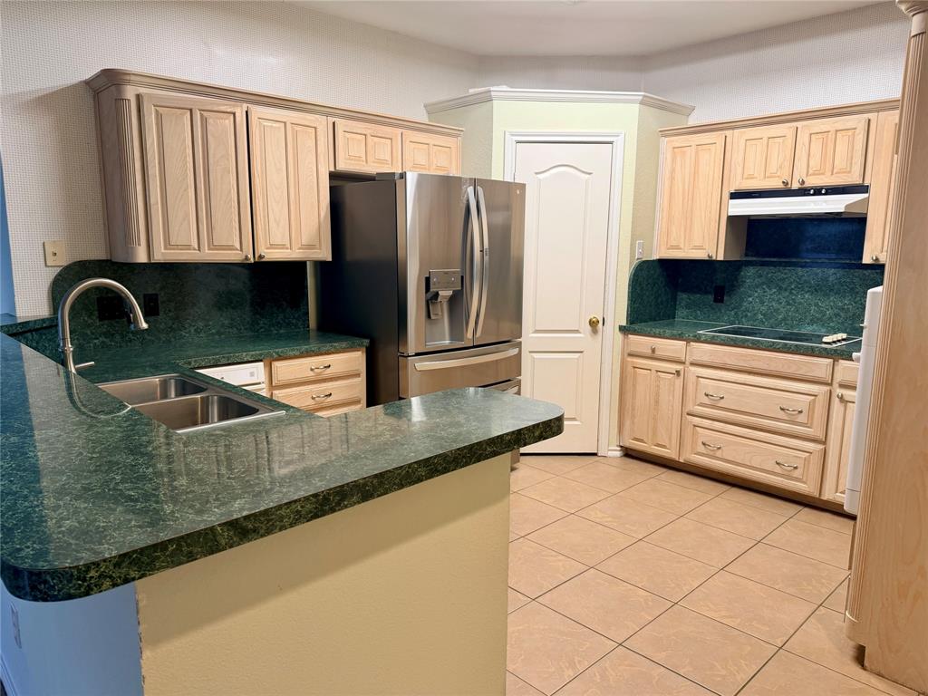 7632 Arbor Ridge Court Fort Worth, TX 76112 - Photo 4 of 19 a kitchen with granite countertop a refrigerator a stove and a sink