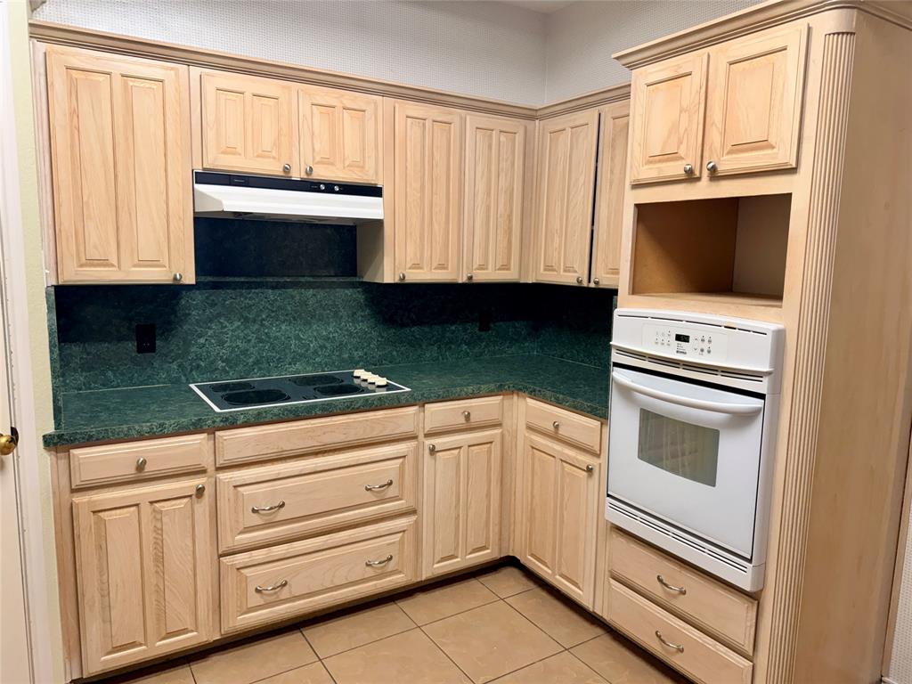 7632 Arbor Ridge Court Fort Worth, TX 76112 - Photo 6 of 19 a kitchen with granite countertop white cabinets and white appliances