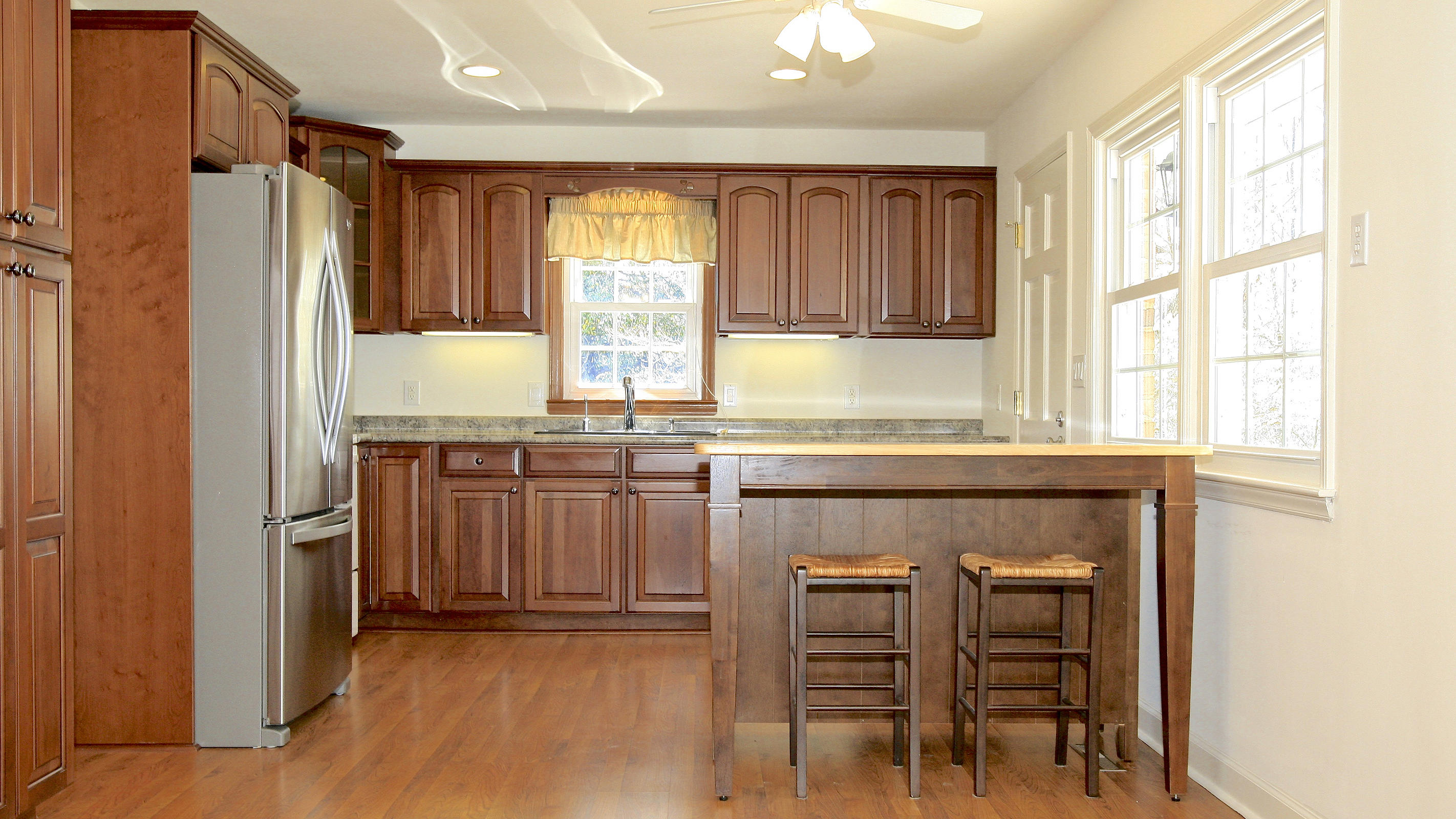 1229 Trails End Road Goodview, VA 24095 - Photo 39 of 106 a kitchen with granite countertop a refrigerator and wooden cabinets