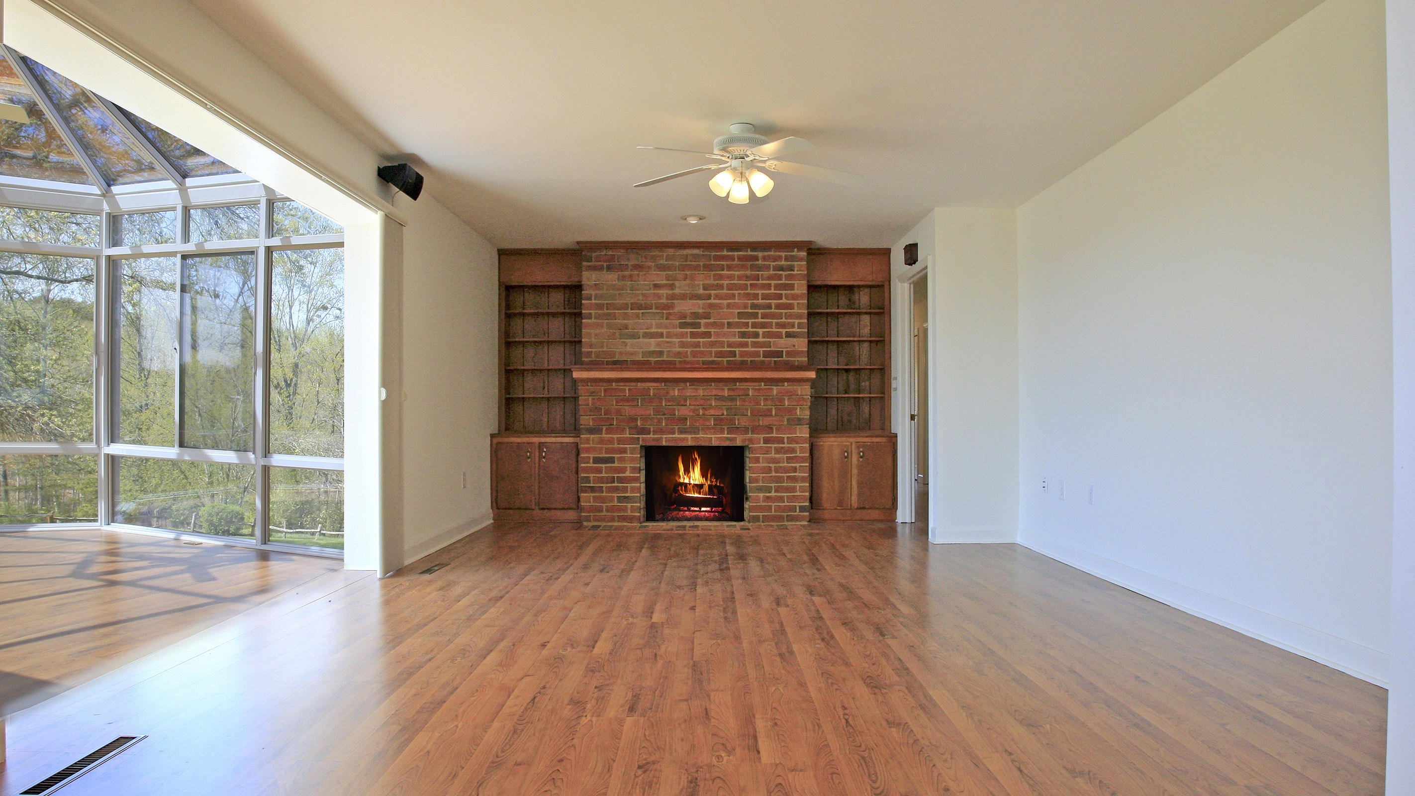 1229 Trails End Road Goodview, VA 24095 - Photo 42 of 106 an empty room with wooden floor fireplace and windows